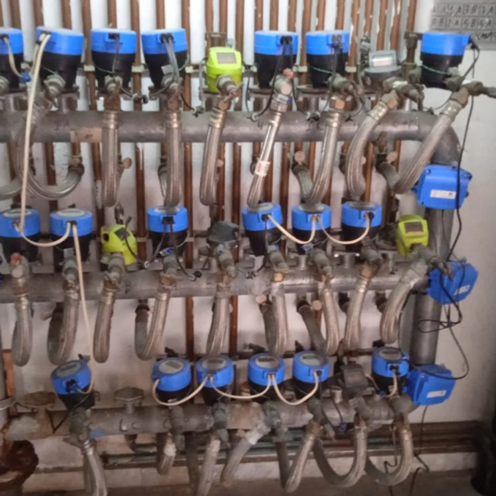 Batería de contadores de agua con llaves de paso y conexiones flexibles.